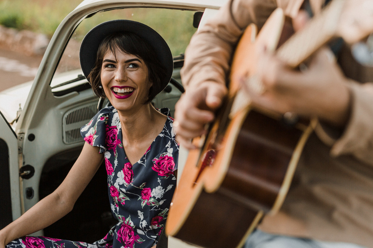 Noiva sorrindo para noivo enquanto ele toca violão. Foto feita pelo fotógrafo de casamento Gabriel Pelaquim.