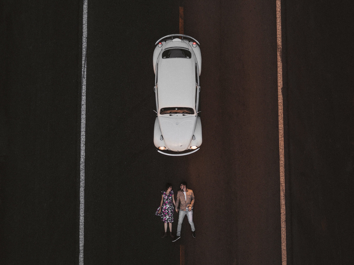 Casal deitado em estrada em Brasília. Foto feita pelo fotógrafo de casamento Gabriel Pelaquim.
