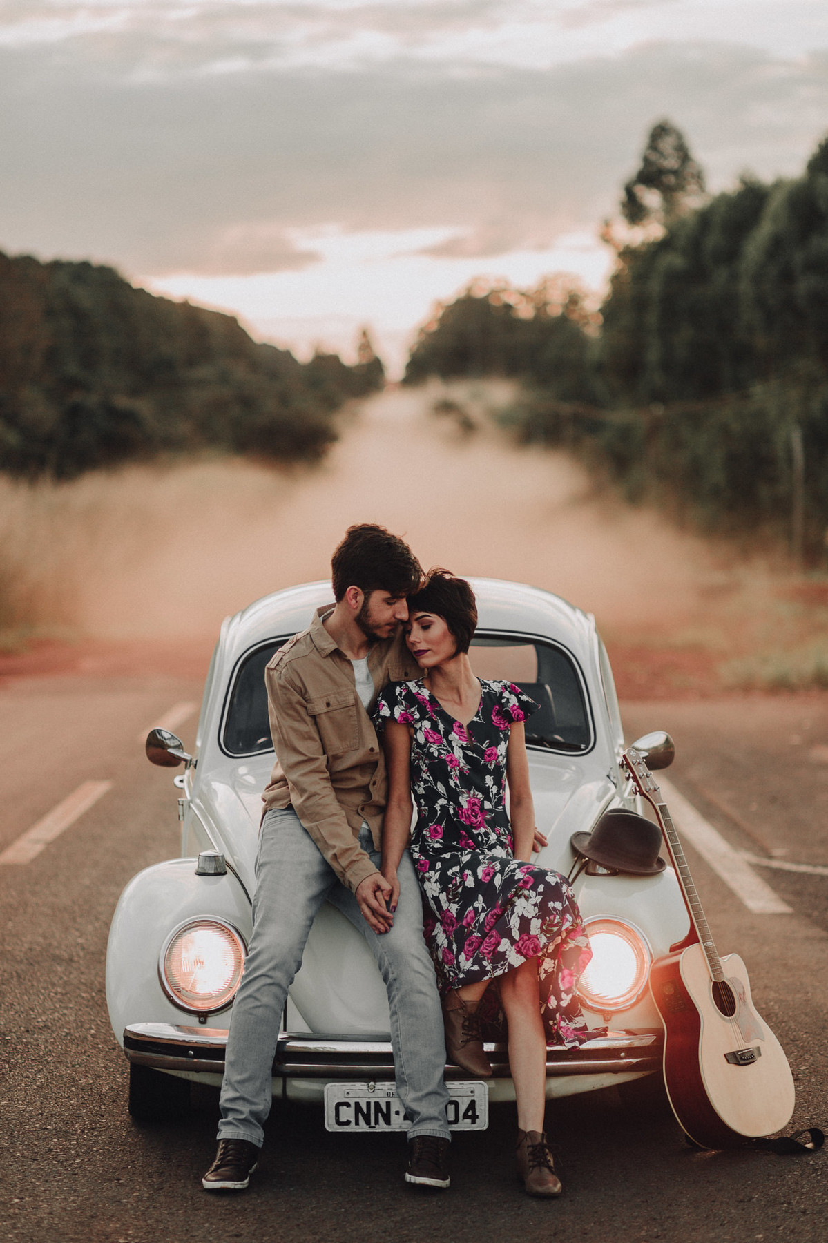 Casal abraçado em capô de fusca em estrada em Brasília. Foto feita pelo fotógrafo de casamento Gabriel Pelaquim.