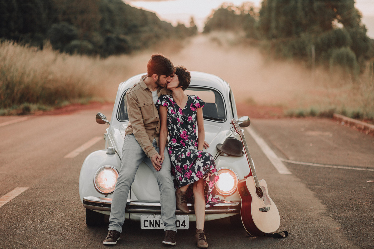Casal abraçado se beijando no capô de um fusca em estrada em Brasília. Foto feita pelo fotógrafo de casamento Gabriel Pelaquim.