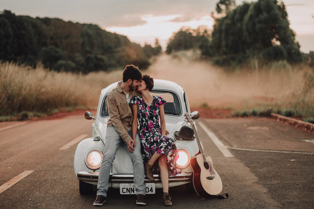 Casal sentado em capô de fusca em estrada em Brasília. Foto feita pelo fotógrafo de casamento Gabriel Pelaquim.