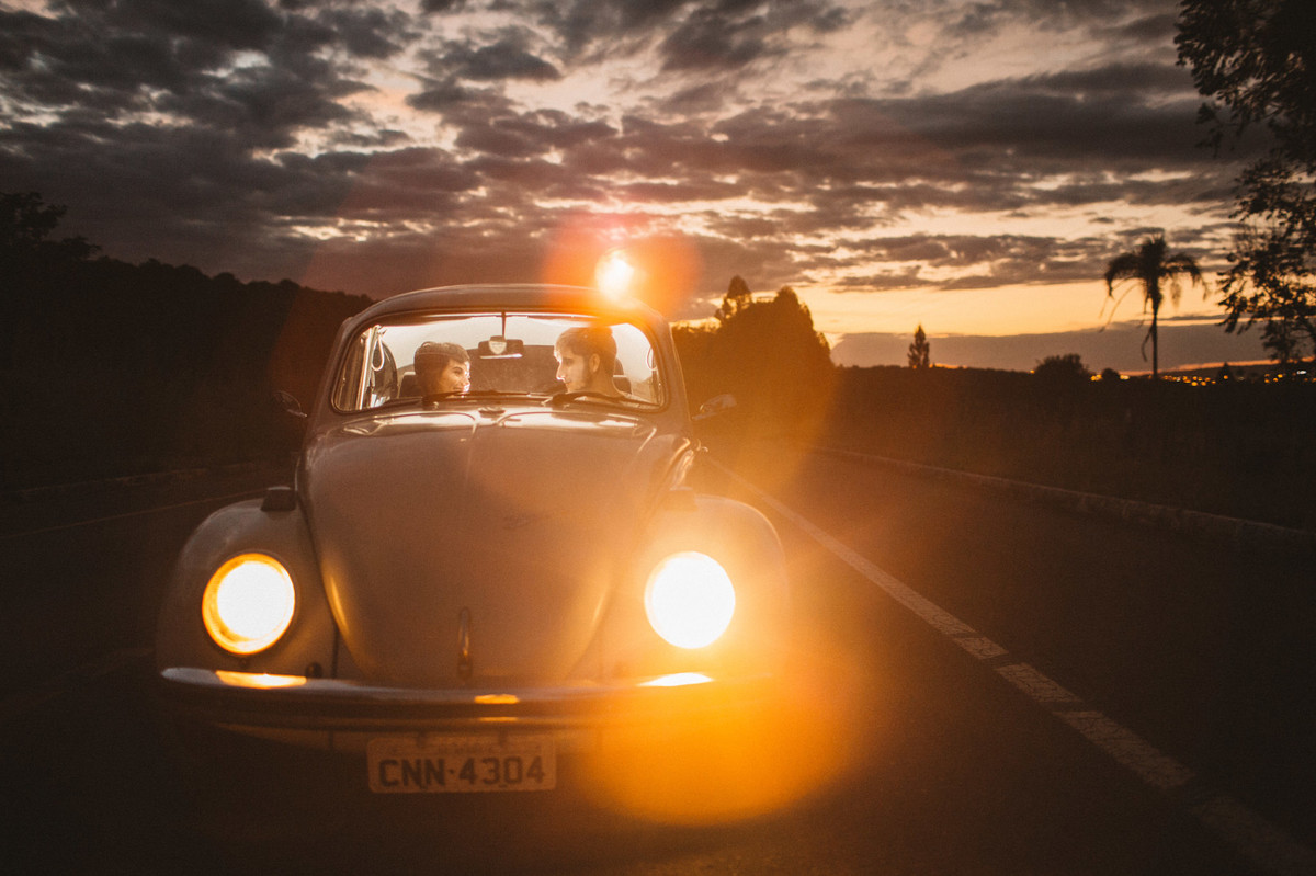 Casal dentro de fusca em estrada em Brasília. Foto feita pelo fotógrafo de casamento Gabriel Pelaquim.