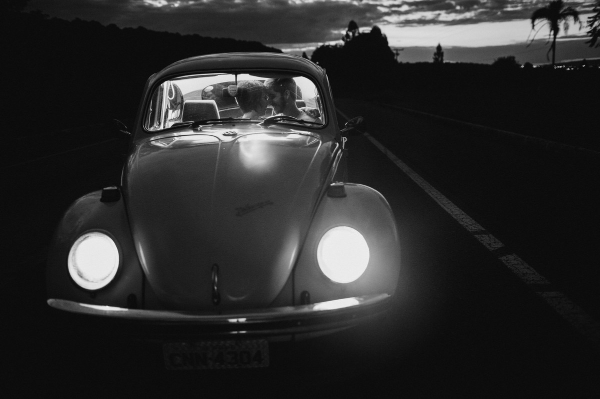 Casal dentro de fusca em estrada em Brasília. Foto feita pelo fotógrafo de casamento Gabriel Pelaquim.