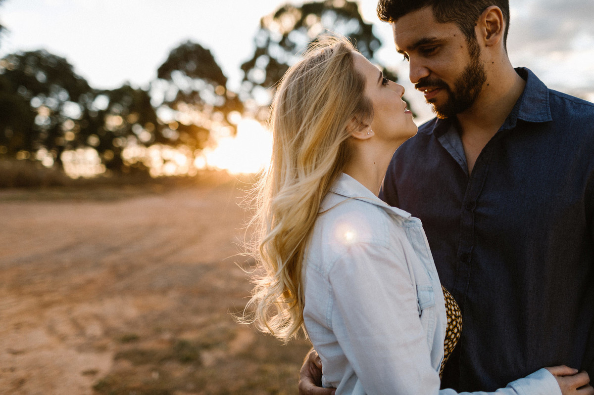 Casal abraçado sorrindo durante o pôr-do-sol em Brasília. Foto feita pelo fotógrafo de casamento Gabriel Pelaquim.