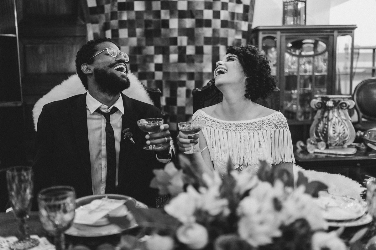 Noivos sentados à mesa. Foto feita pelo fotógrafo de casamento Gabriel Pelaquim.
