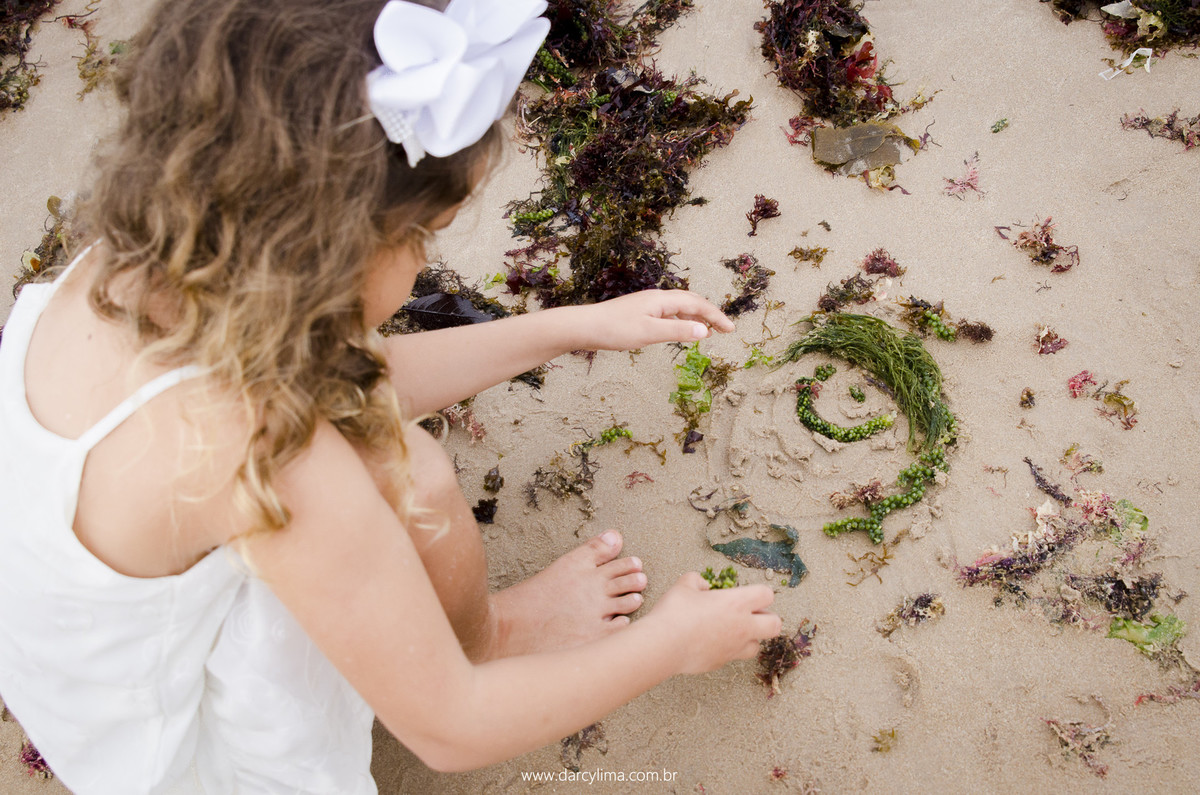 filha mais nova pega algas do mar para fazer um boneco de seu irmão