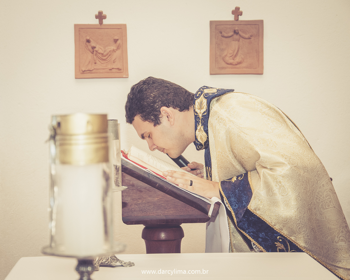padre na igreja beijando a biblia