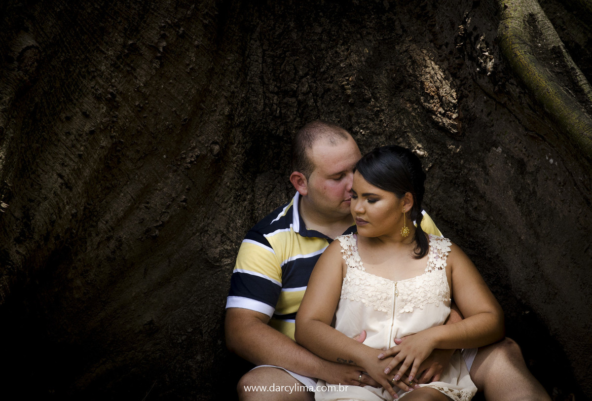 casal de noivos sentados na raiz de uma arovore