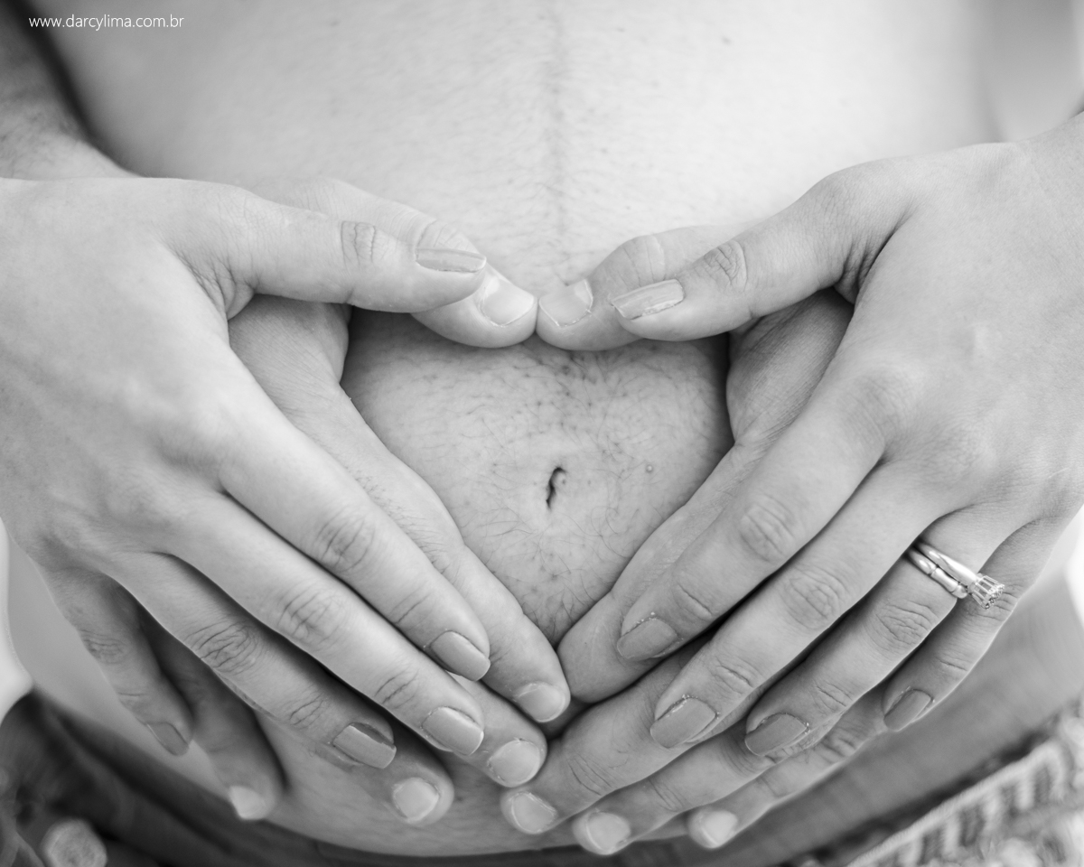 maos em cima da barriga formando um coração