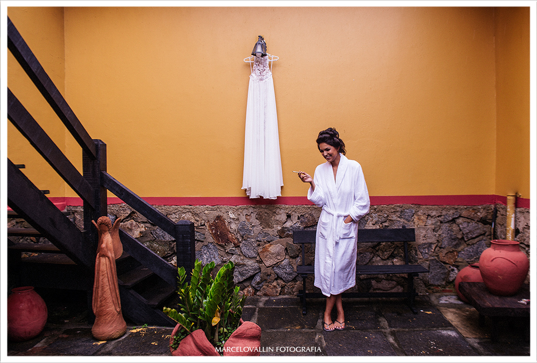 Fotografia da Noiva ao lado do vestido de noiva na pousada tanto mar
