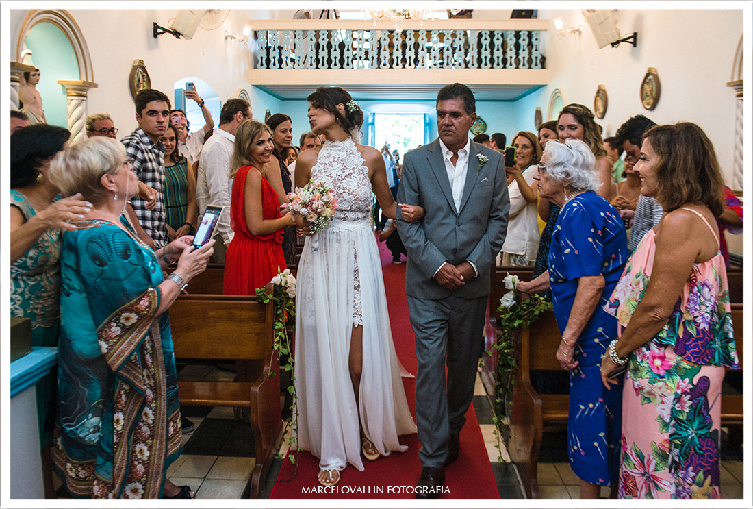 Noiva mandando beijo na entrada da Igreja nossa Senhora dos Remédios em Arraial do Cabo