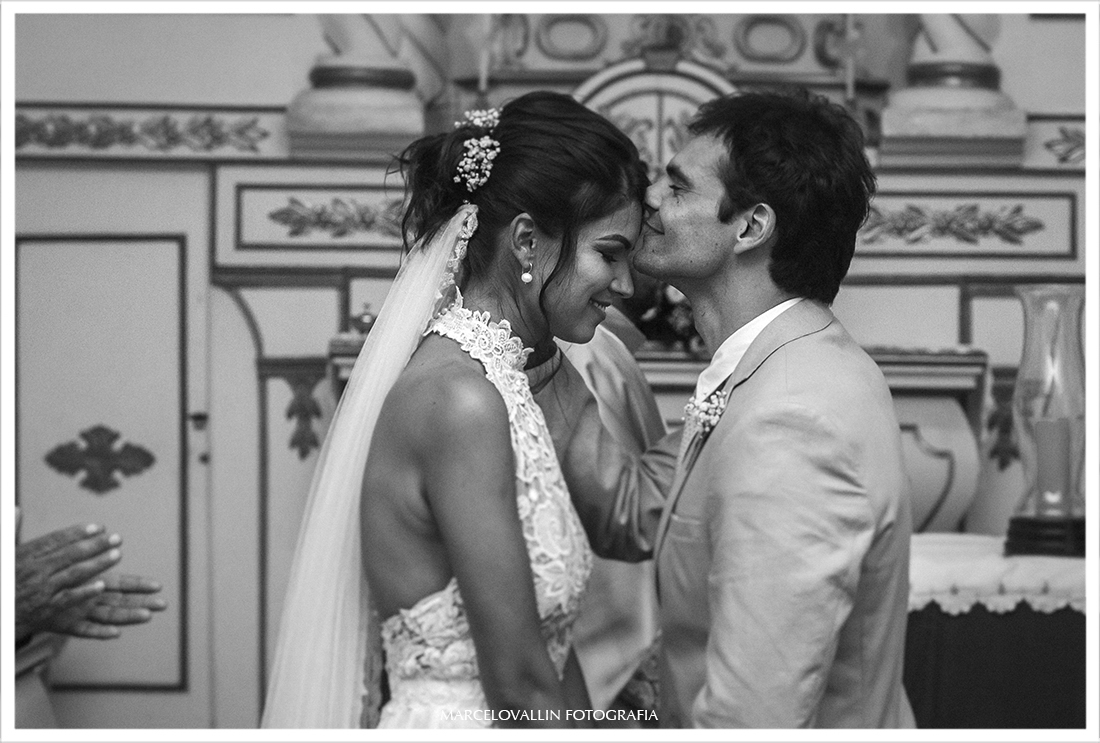Noivo beijando a testa da noiva na cerimonia de casamento
