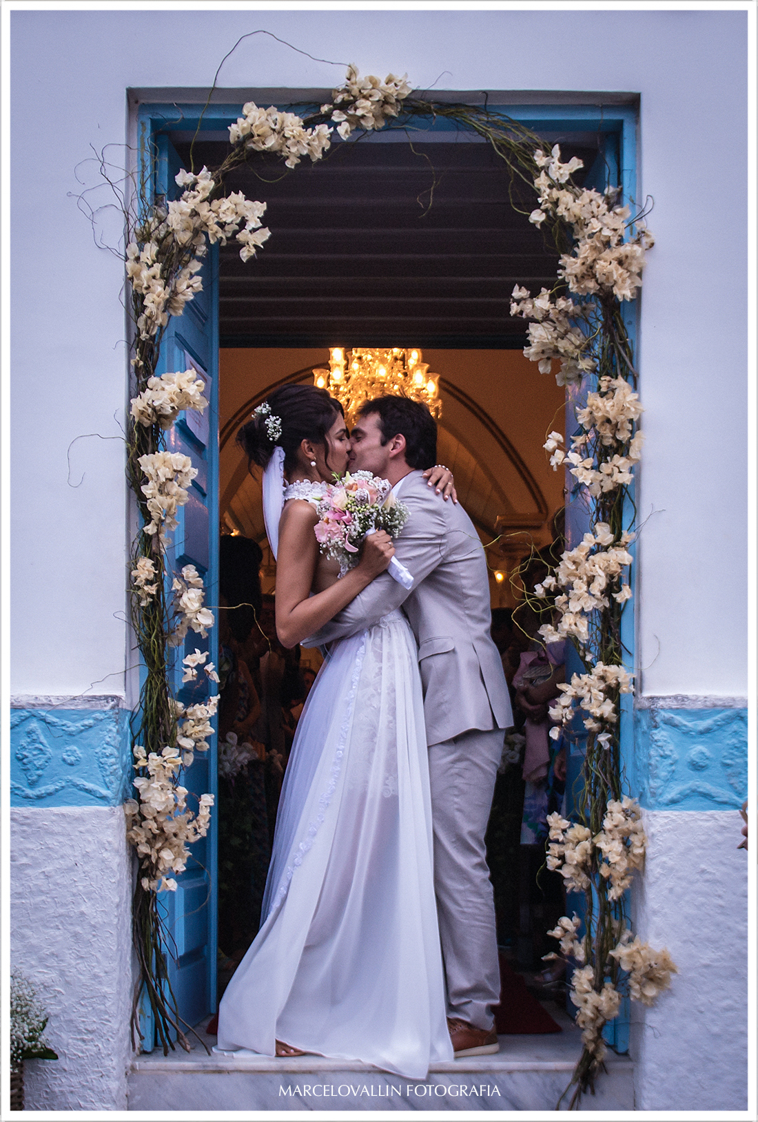 Noivos se beijando na porta da Igreja