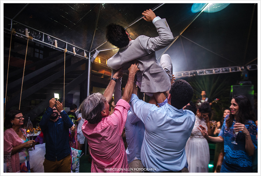 Amigos jogando noivo para o alto em festa de casamento