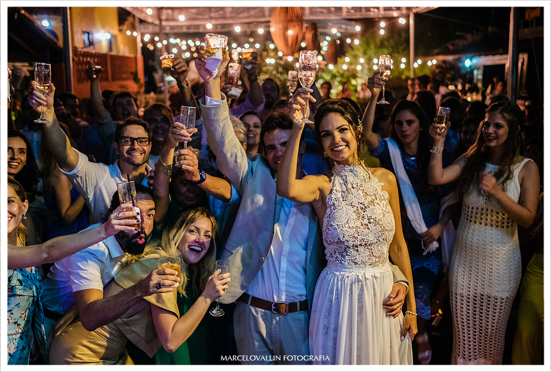 Foto dos noivos fazendo um brinde com amigos - Arraial do cabo