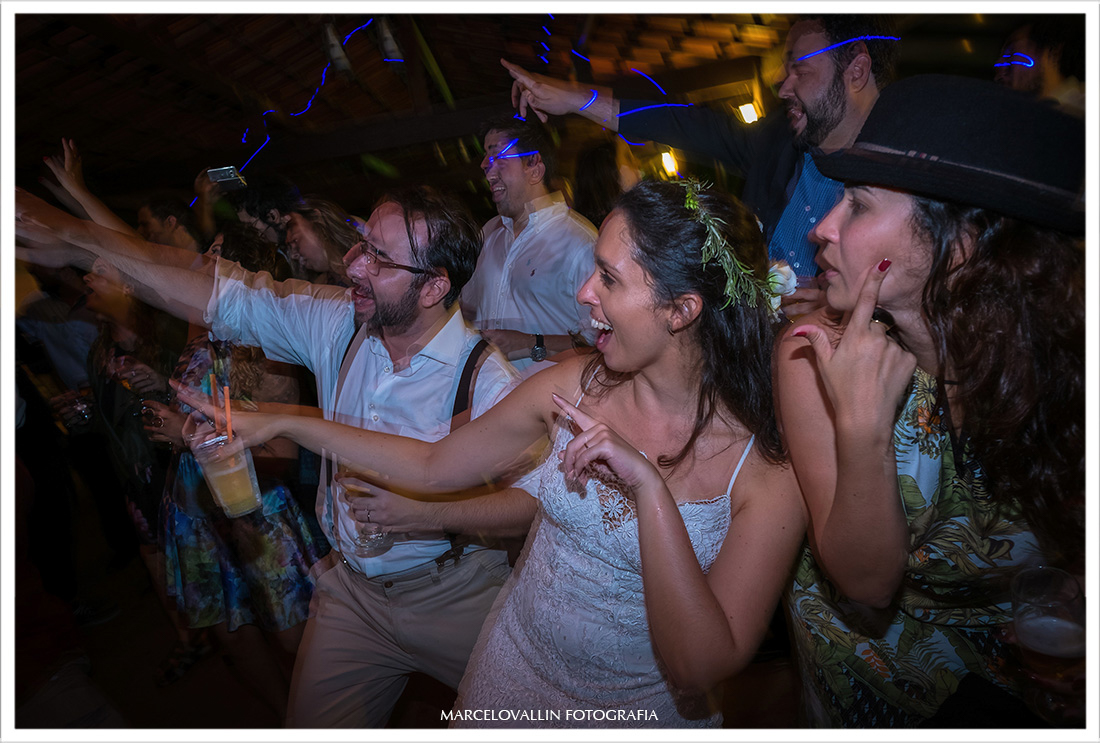 Noivos e amigos dançando em festa de casamento