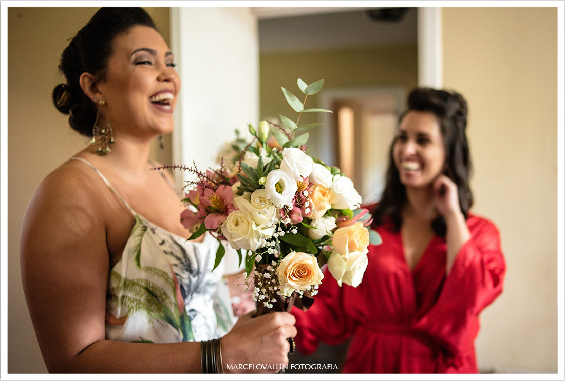 Madrinha sorrindo e entregando Buquê para noiva