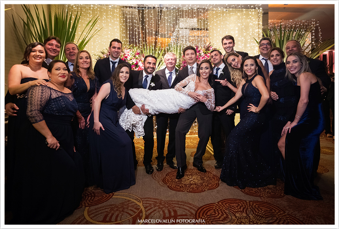 Fotografia da noiva no colo dos padrinhos