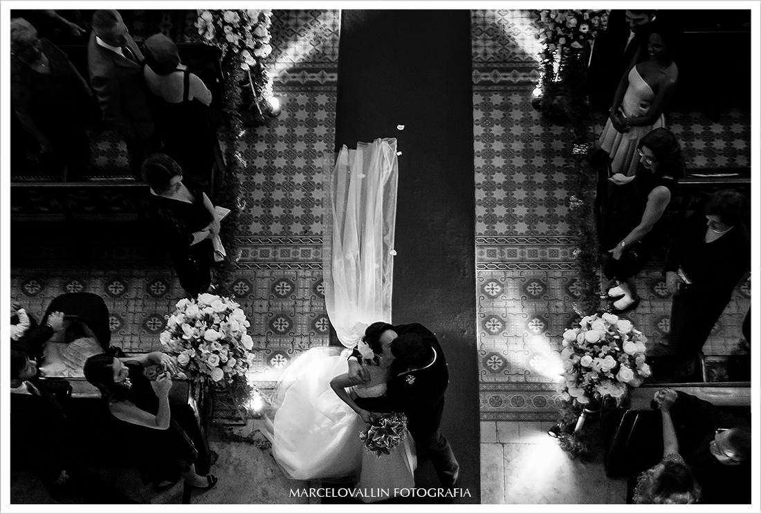 Fotografia dos noivos se beijando na saída da Igreja São José