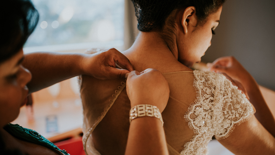 mãe colocando o vestido na noiva
