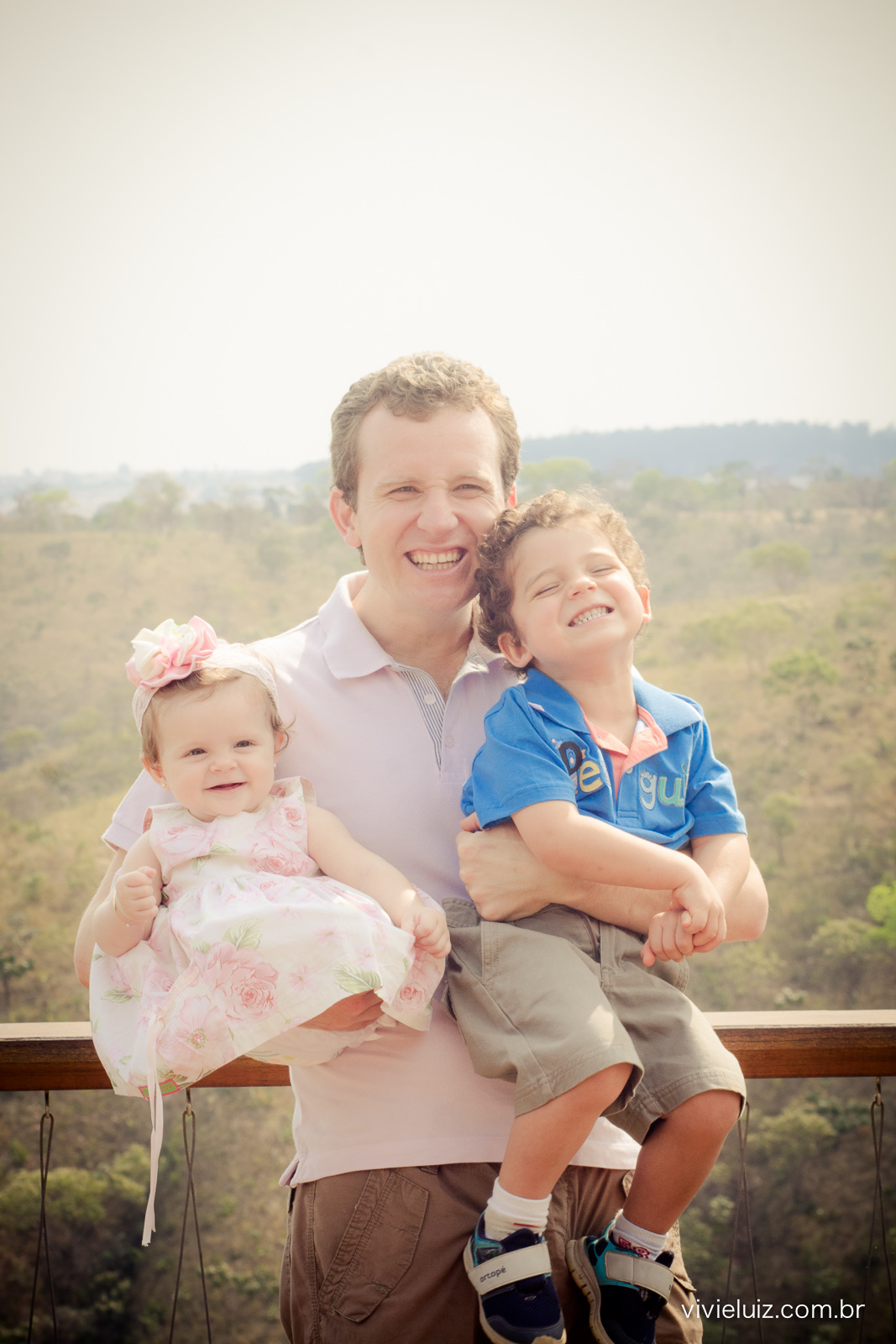 pai com filhos no colo na varanda