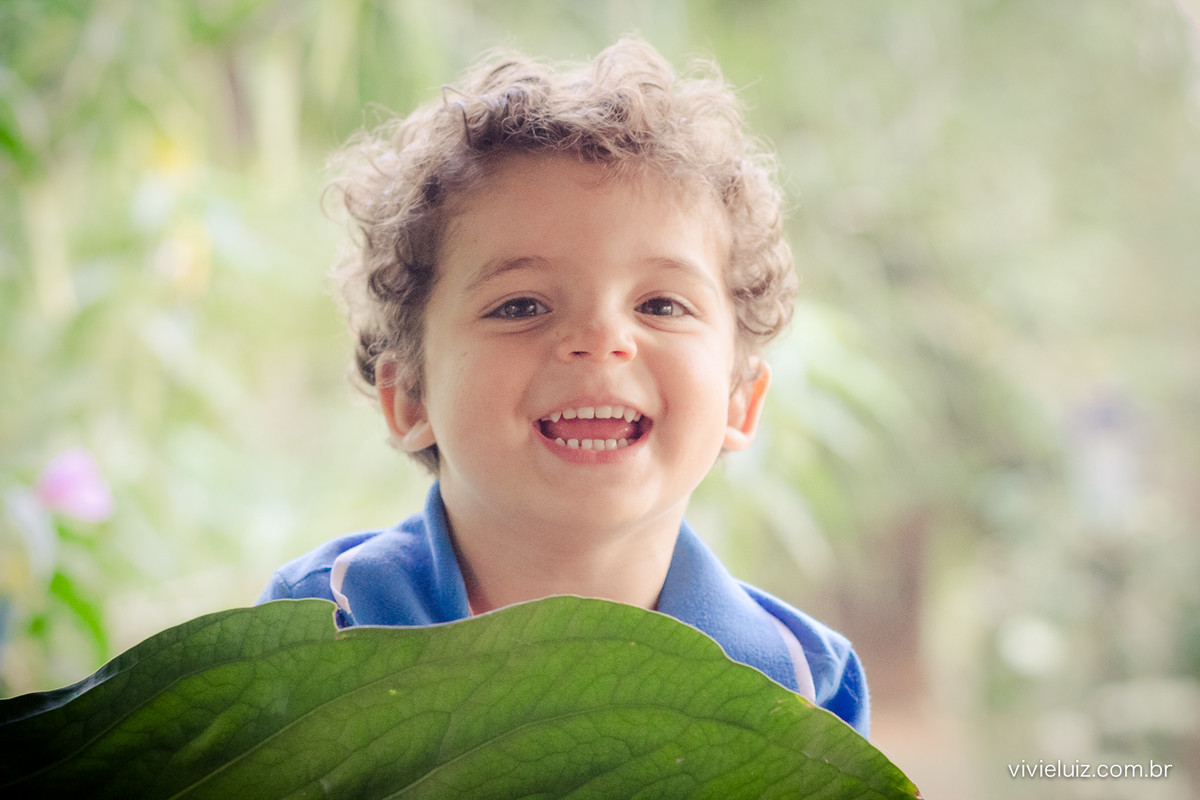 sorriso de criança com uma folha verde