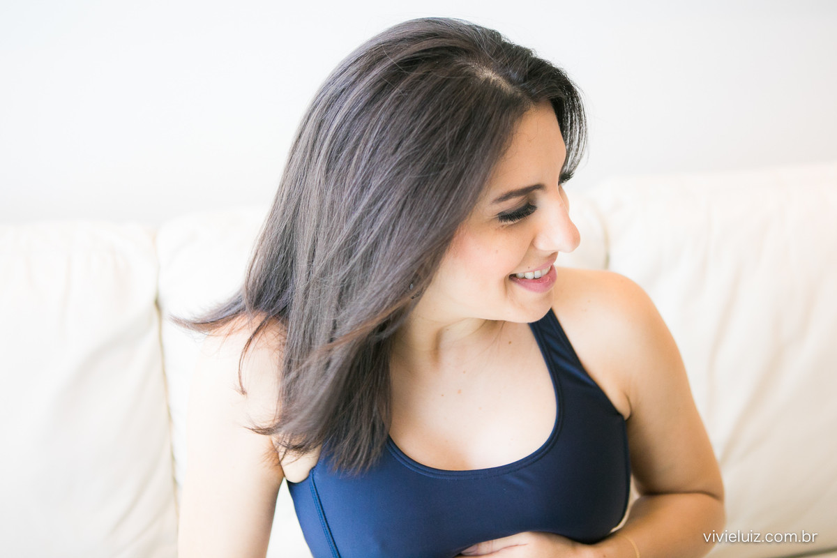 Grávida no sofá abraçando barriga