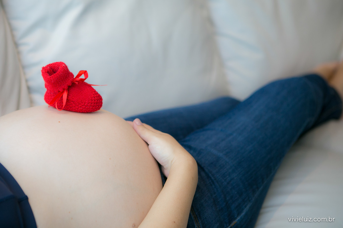 Grávida com sapatinhos do bebê na barriga