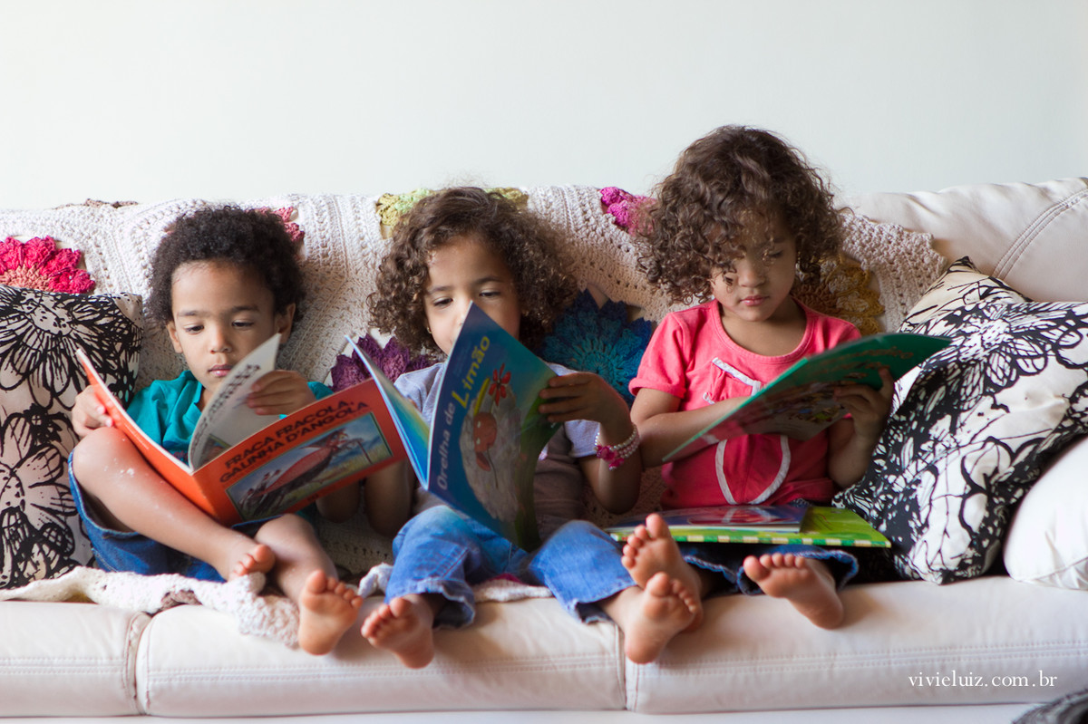 Trigêmeos lendo um livro