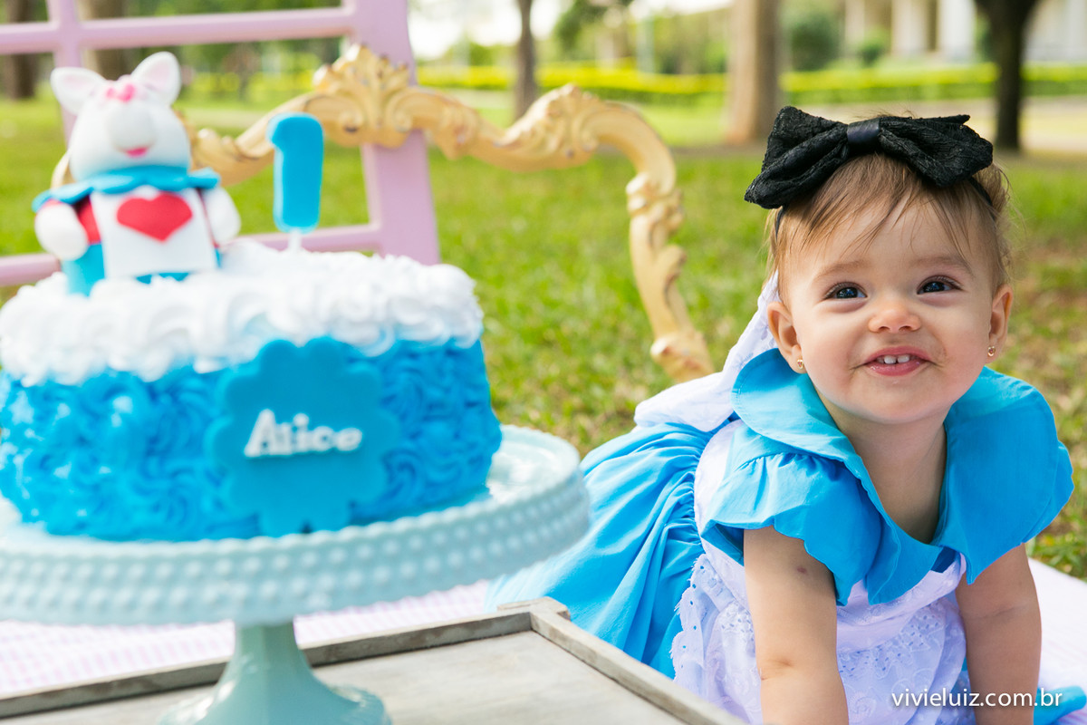 Criança com fantasia da Alice comendo bolo