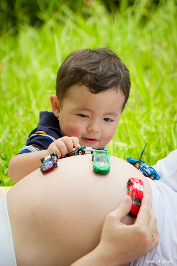 Irmão brincando de carrinho Na barriga dar mãe gestante