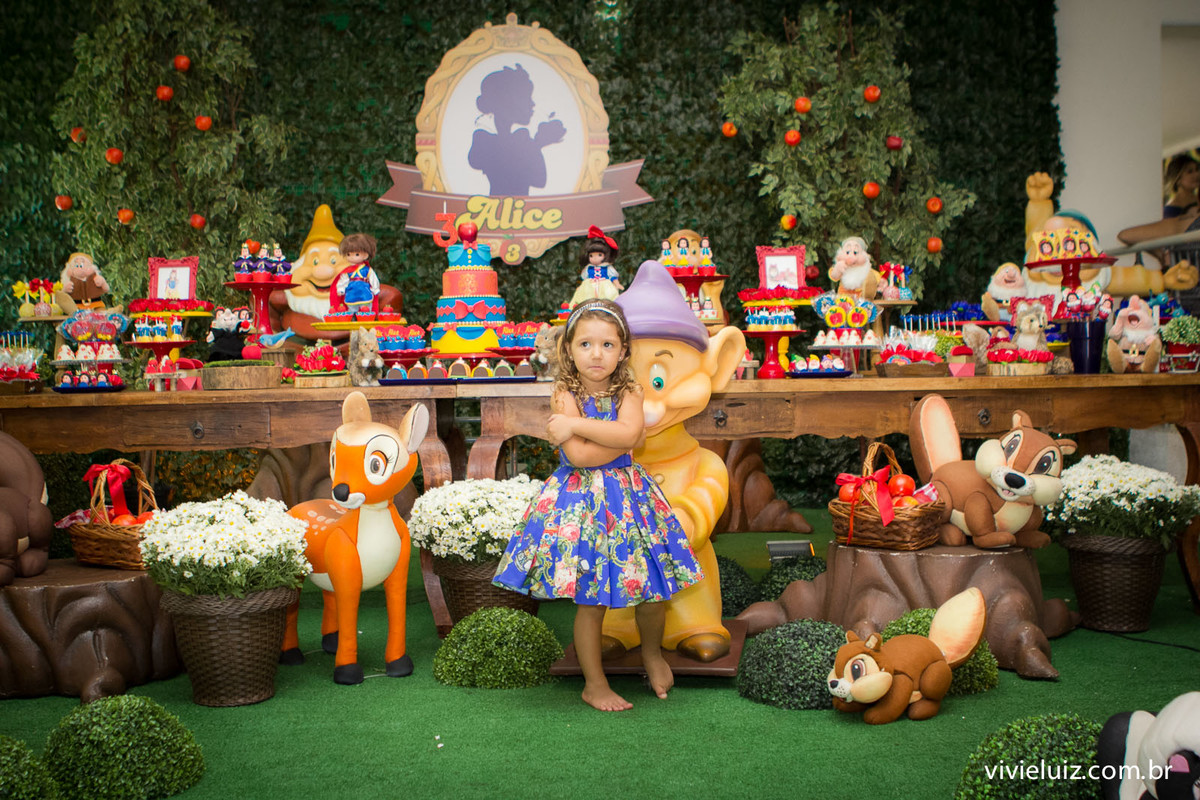 alice na mesa do bolo da branca de neve