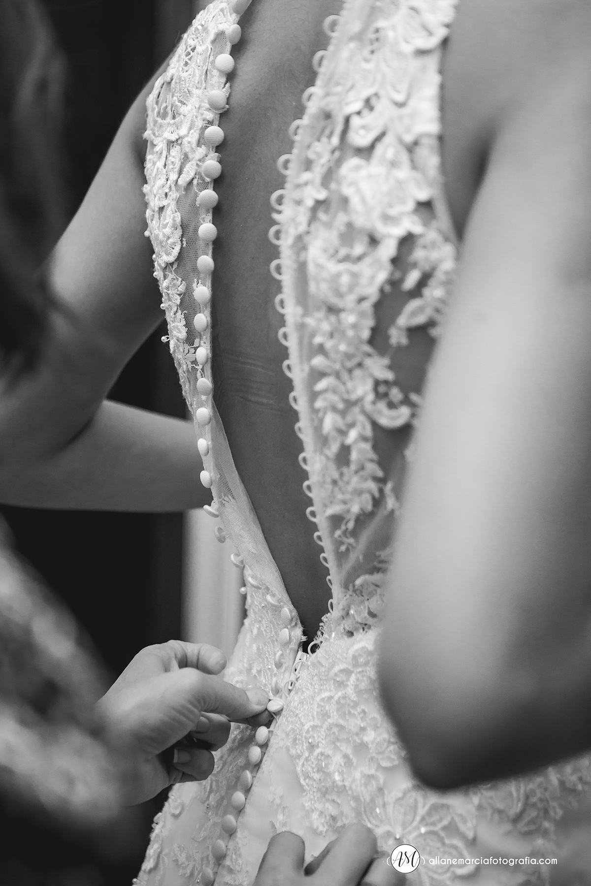 mãe fechando o vestido da noiva