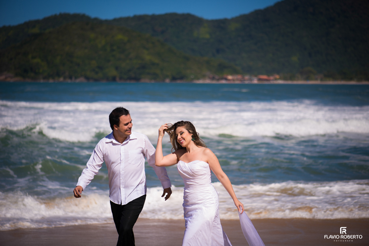 recém casados caminhando na praia