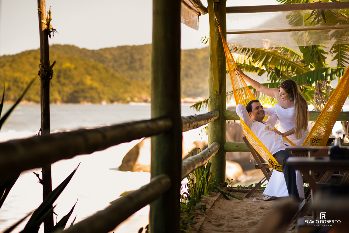 Casal deitando na rede la beira da praia