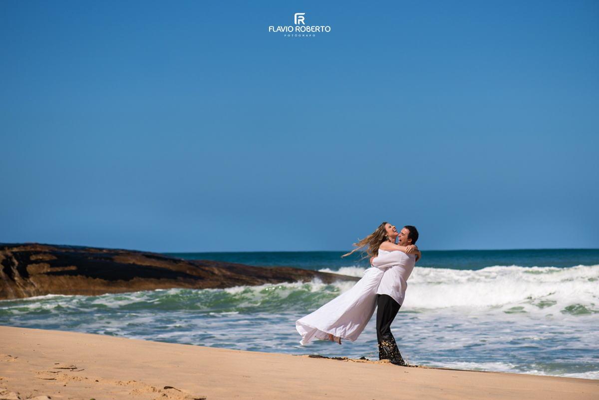 casal se abraçando na praia