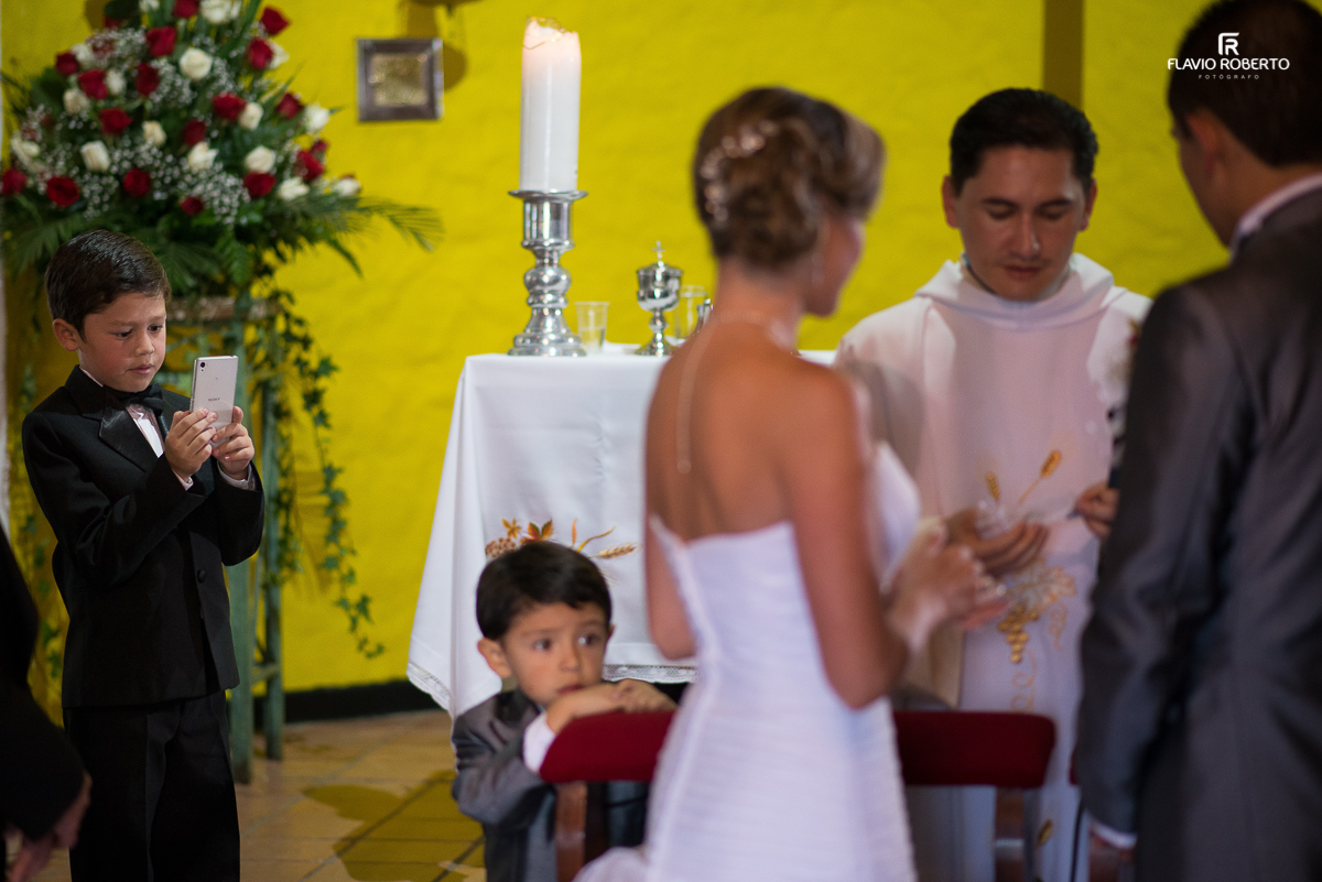 criança fotografando os noivos na cerimonia de casamento