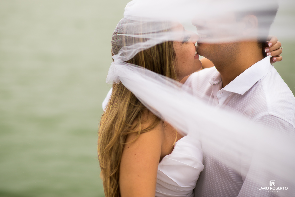 Noivos se beijando embaixo do veu