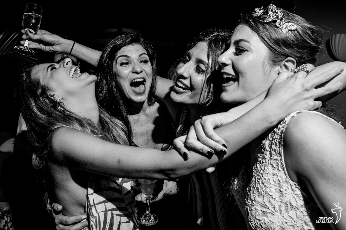 noiva e amigas sorrindo e cantando na festa de casamento
