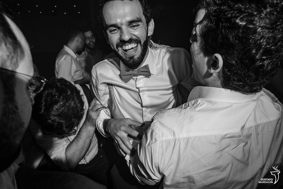 noivo sendo jogado para o alto na festa de casamento