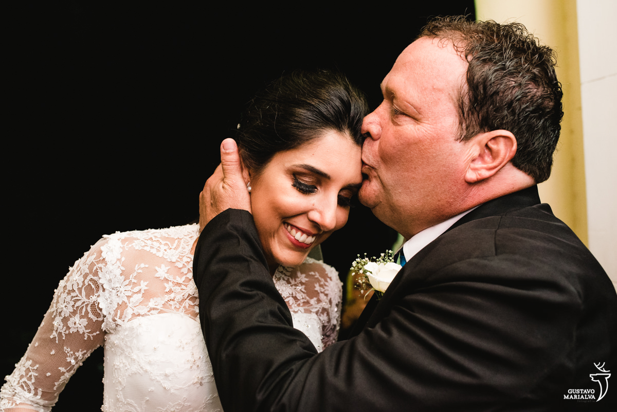 pai acalmando e beijando a testa da noiva na entrada da igreja na cerimônia de casamento