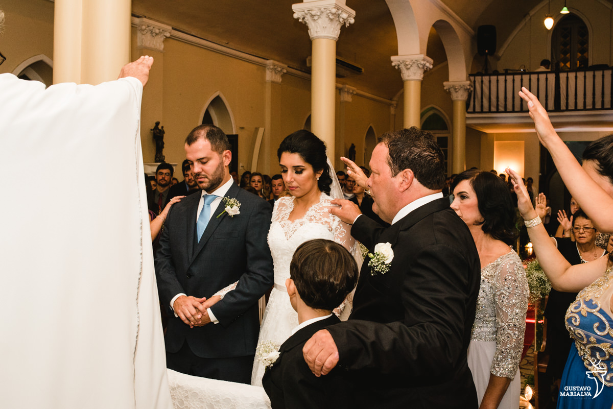 Pais e familiares abençoando os noivos na cerimônia de casamento