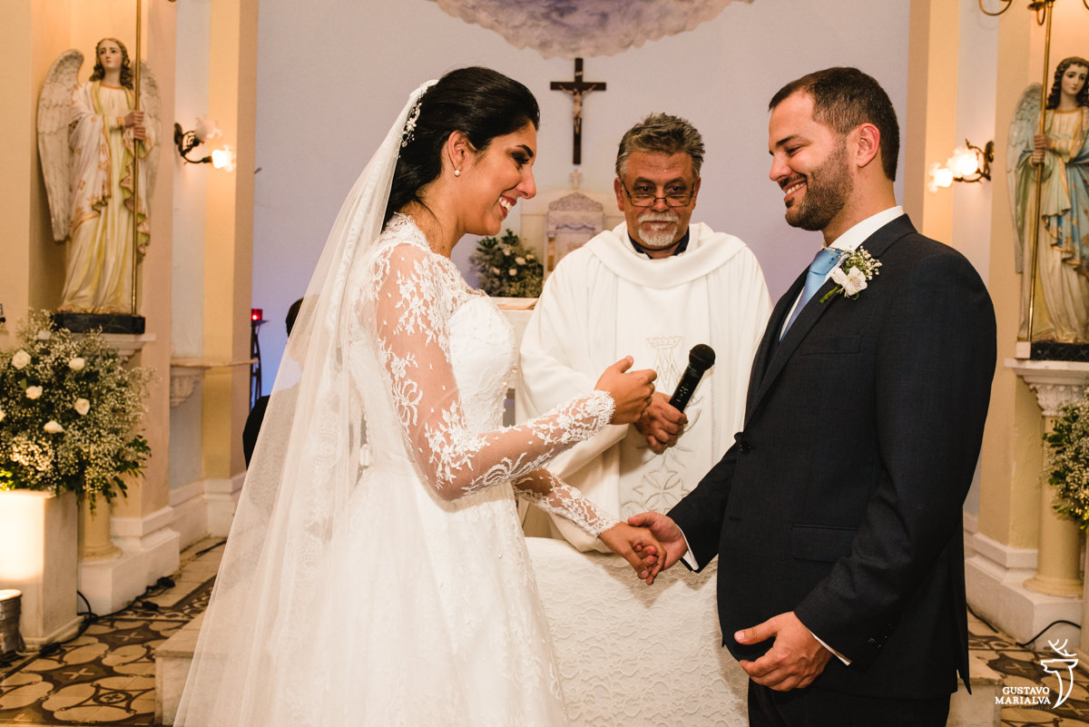 Noivos sorrindo ao trocarem votos na cerimônia de casamento