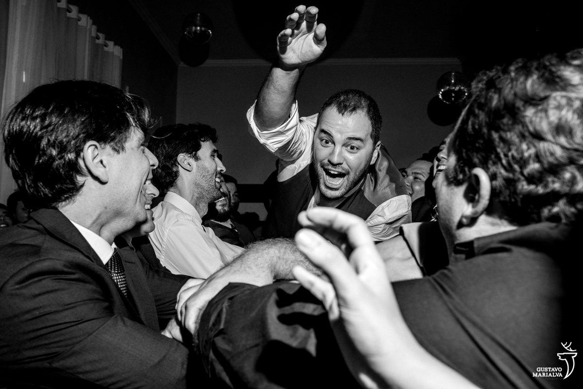 Padrinhos jogando o noivo para o alto na festa