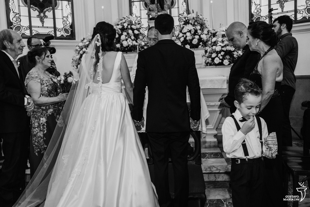 pajem comendo pipoca durante a cerimônia de casamento