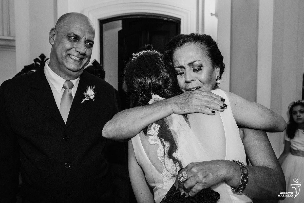 mãe do noivo abraçando a noiva emocionada