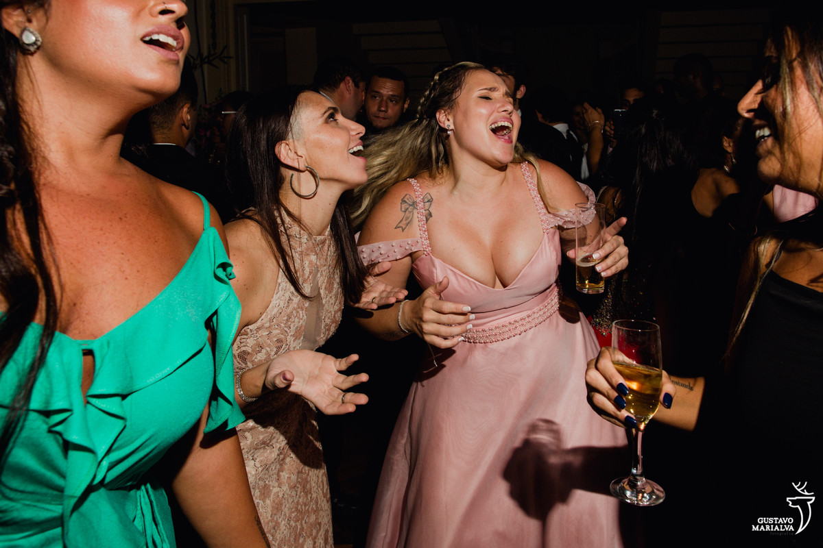 amigas cantando música e segurando espumante na festa de casamento no fluminense