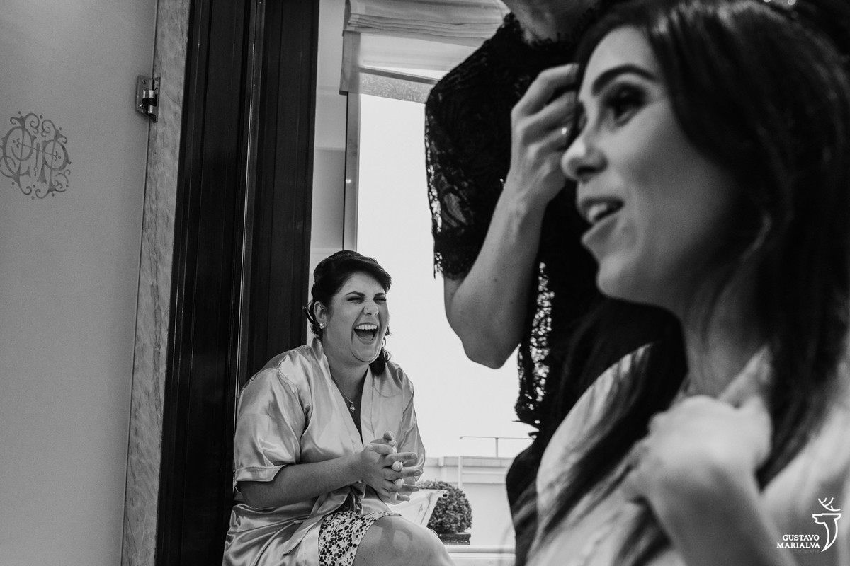 madrinha sorrindo com a noiva contando história engraçada