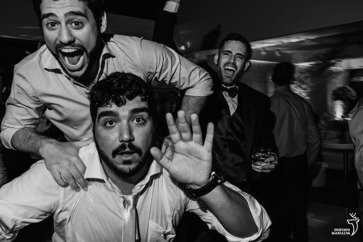 convidado pulando nas costas do amigo enquanto o noivo dança sorridente na festa de casamento no clube mandala no rio de janeiro