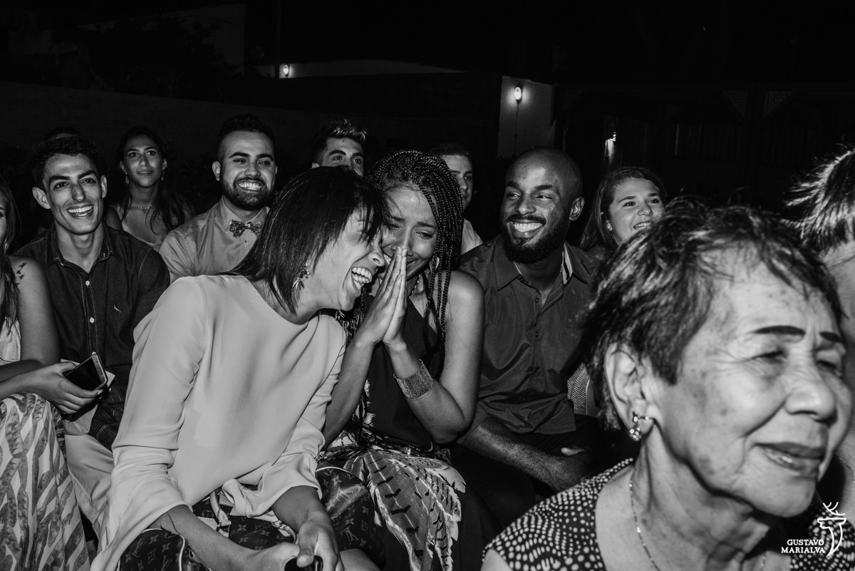 Convidados choram e sorriem emocionados com a troca de votos dos noivos na cerimônia de casamento no Uniq Beach Lounge em Búzios